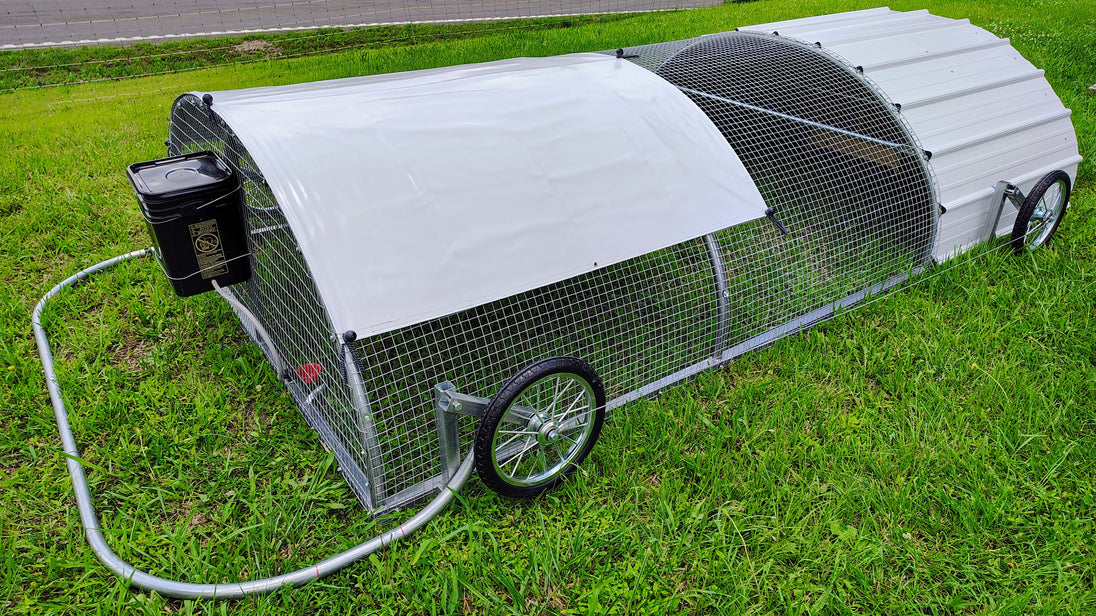 Portable chicken coop with wheels on a grassy area