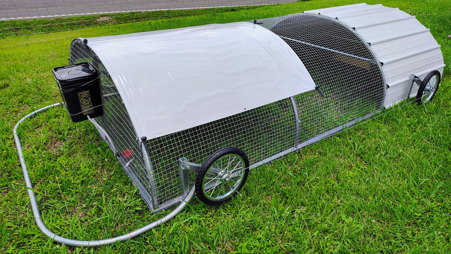 Portable chicken coop with wheels on a grassy area