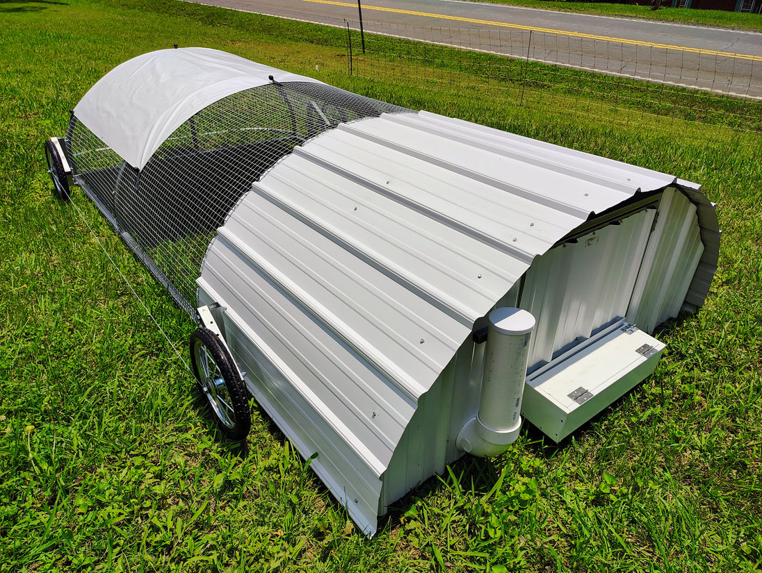 Portable chicken coop on wheels in a grassy area