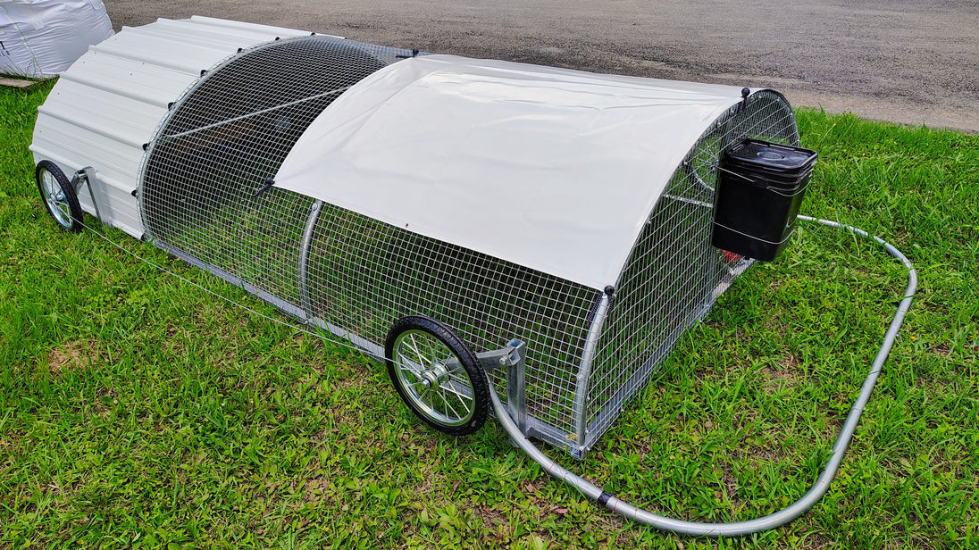 Portable chicken coop with wheels on a grassy area