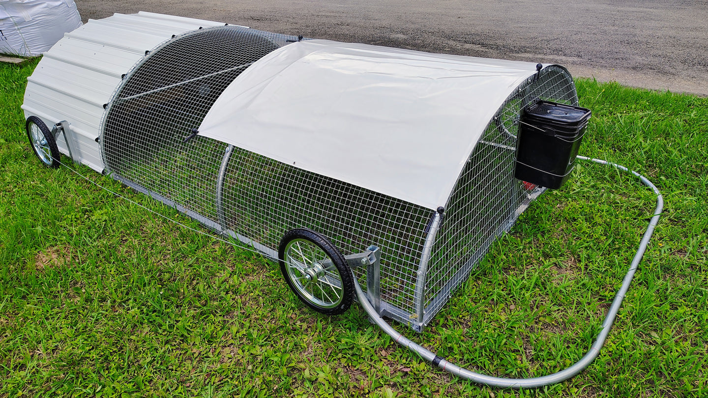 Portable chicken coop with wheels on a grassy area