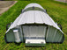 Portable metal shelter on wheels in a grassy area